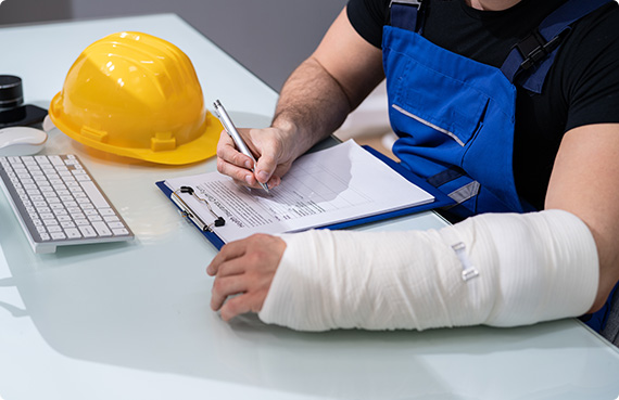 Worker with arm cast filling out insurance claim form - Cut Down The Processing Time On Your Disability Insurance Claim - California Disability Law Office