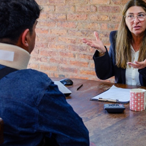 A legal professional explaining medical evidence to a client in a neck brace.
