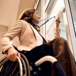 A woman in a wheelchair looking out a window, representing non-medical SSDI criteria.