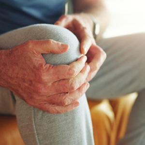 A person clutching their side in pain, representing a liver disease disability claim.