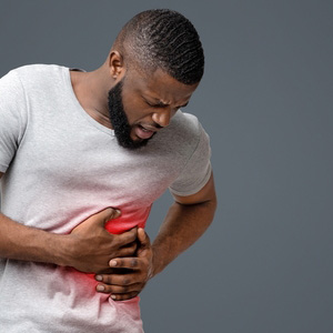 A man clutching his side in pain, representing cirrhosis and liver disease claims.