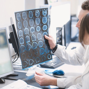 A medical professional reviewing brain MRI scans for an MS disability application.