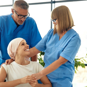 A smiling patient receiving care from medical professionals during treatment.