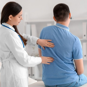A medical professional examining a patient's back for a scoliosis disability claim.