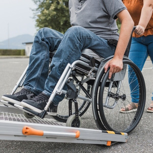 A person in a wheelchair using a van ramp to represent employment and benefits.