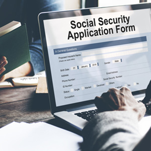 A person using a laptop to fill out a Social Security disability application form.