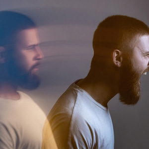 A split-exposure portrait of a man representing complex mental health disability.